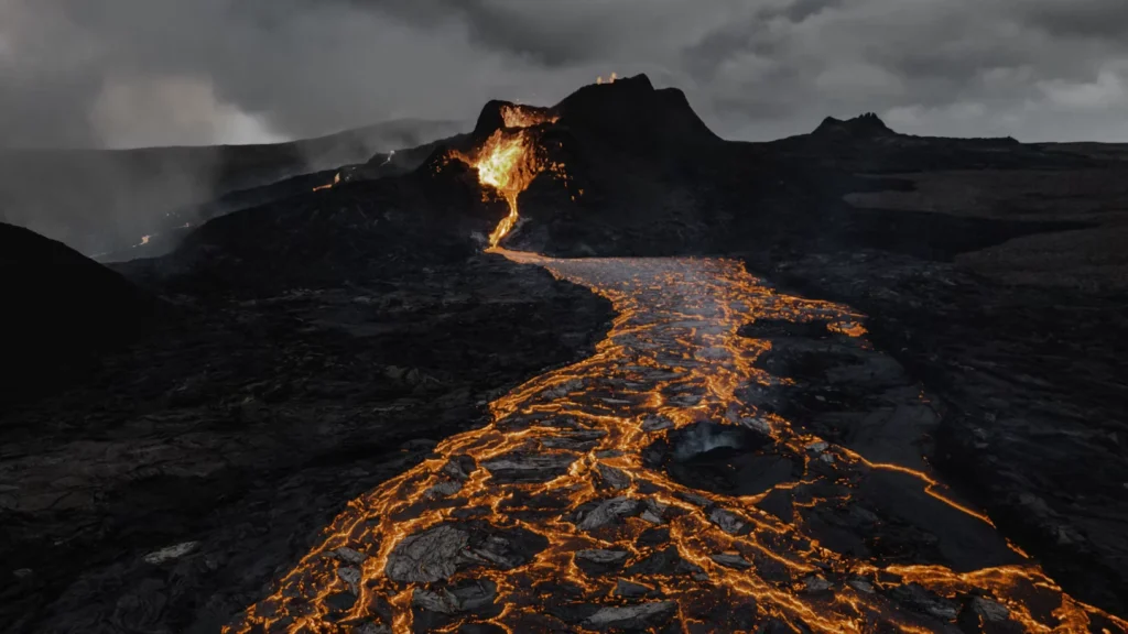 Fluxo de lava incandescente durante uma erupção de um dos vulcões mais impressionantes da natureza em terreno rochoso escuro